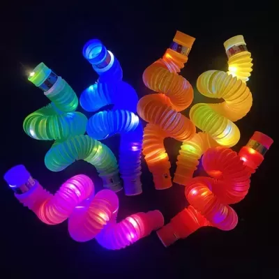 Brinquedos flexíveis em espiral com luzes LED de várias cores num fundo escuro