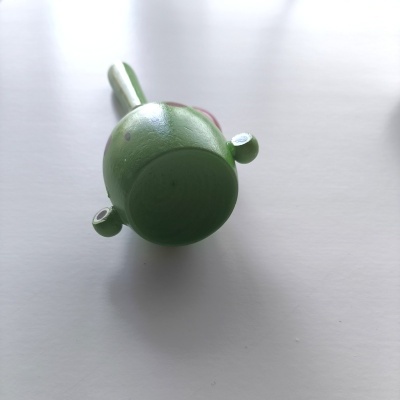 Miniatura de dinossauro verde em plástico sobre superfície branca