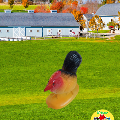 Brinquedo de galinha com corpo amarelo, cabeça vermelha e cauda preta com campo verde e celeiros ao fundo