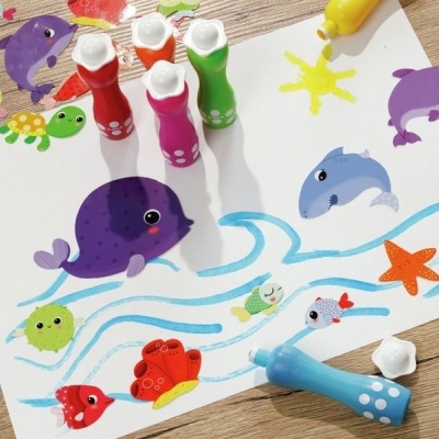 Conjunto de tinta colorida e pincel com desenhos de animais marinhos numa folha branca