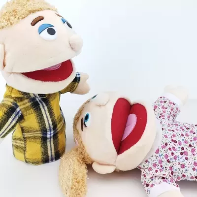 Duas marionetas de mão vestidas, uma com camisa xadrez amarela e outra com vestido floral.