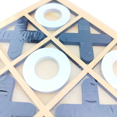 Jogo de tic-tac-toe em madeira e peças preto e branco