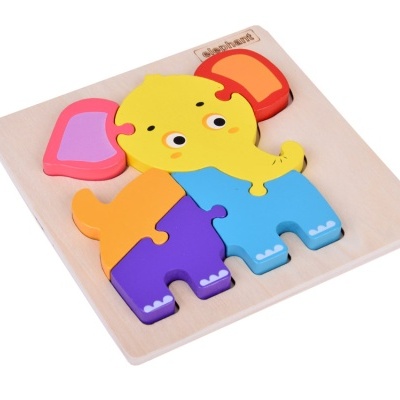 Quebra-cabeças de madeira colorido em forma de elefante numa base de madeira clara