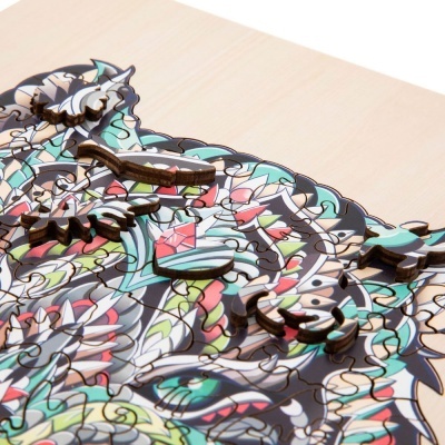 Peças coloridas de puzzle de madeira com padrão complexo sobre fundo de madeira clara