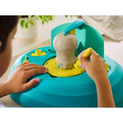 Base elétrica azul para escultura com massa moldável e mãos de criança esculpindo