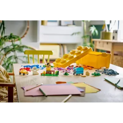 Mesa com peças de Lego coloridas e estojo amarelo aberto para armazenamento