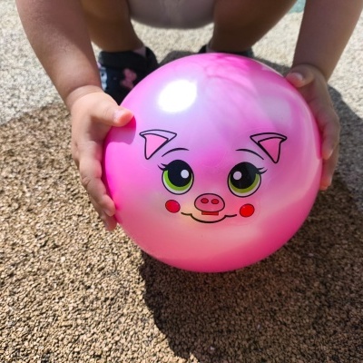 Bola cor-de-rosa com rosto de porquinho sorridente