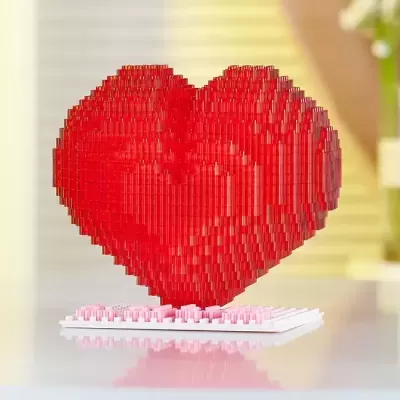 Escultura de coração vermelha feita de blocos de construção sobre base branca