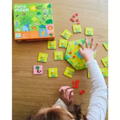 Jogo de memória MEMO PALEUM com cartas ilustradas e peças pequenas numa mesa de madeira