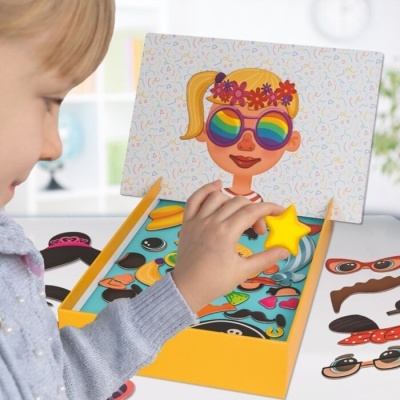 Criança a brincar com jogo magnético de rosto e acessórios coloridos