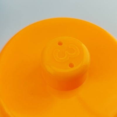 Tampa laranja de plástico com marca em relevo e aberturas circulares