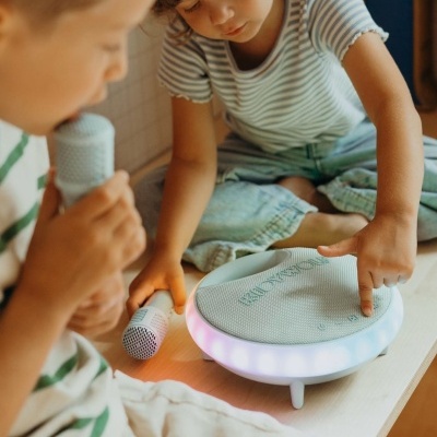 Crianças com microfone e coluna portátil branca com luz LED colorida