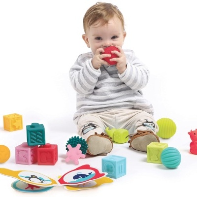 Criança sentada com brinquedos coloridos ao redor