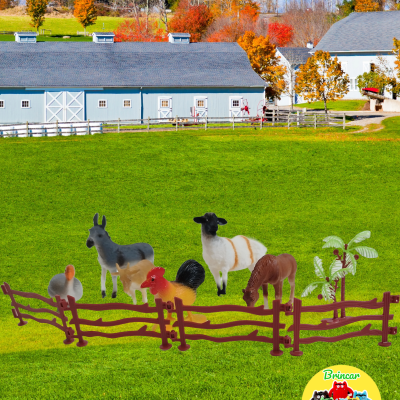 Brinquedos animais de quinta em plástico com cerca marrom numa paisagem rural de outono