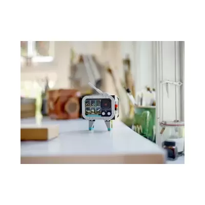 Miniatura de televisão retro de plástico com ecrã colorido numa mesa branca