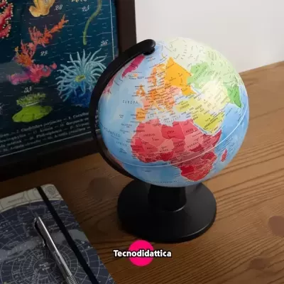 Globo terrestre colorido sobre mesa com caderno, caneta e quadro ao fundo