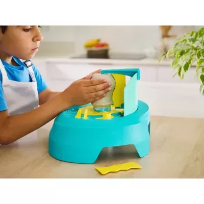 Brinquedo ou ferramenta de cozinha infantil azul e amarelo com frasco invertido, usado por criança numa cozinha