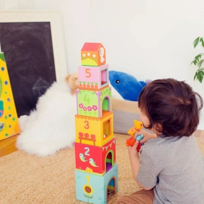 Criança a brincar com blocos de madeira empilhados numerados de 1 a 5