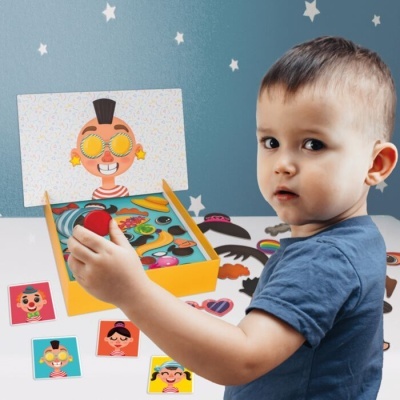 Criança com puzzle magnético de acessórios para rostos coloridos
