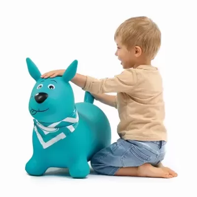 Criança a brincar com brinquedo insuflável em forma de cão azul turquesa.