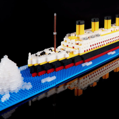 Modelo de navio de blocos com icebergue em base azul, fundo preto