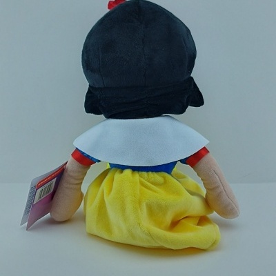 Boneco de peluche de costas com saia amarela e gola branca