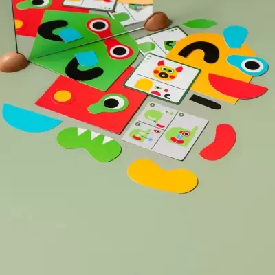 Peças coloridas de jogo de construção facial com espelho e cartas sobre fundo verde claro