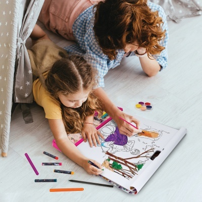 Duas crianças a colorir livro de colorir com lápis e tintas no chão
