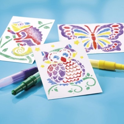 Três desenhos coloridos em papel destacável com marcadores coloridos em superfície azul