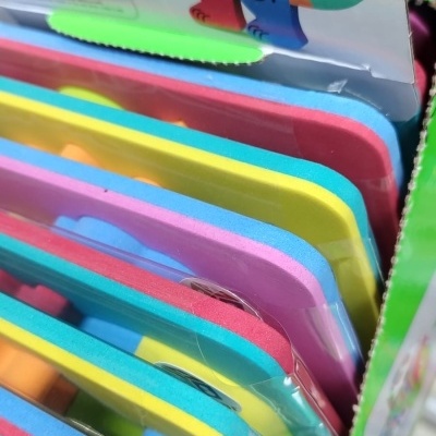 Peças de espuma coloridas para crianças dentro de embalagem verde com ilustração de animal