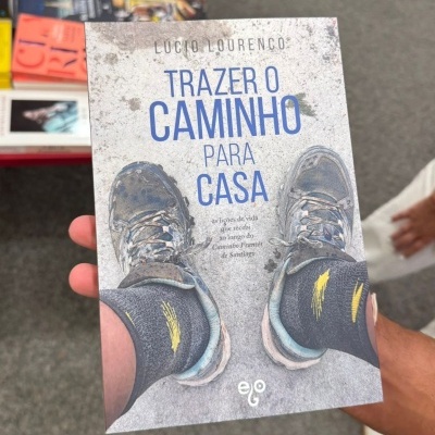 Capa de livro com sapatilhas e texto 'Trazer o caminho para casa'