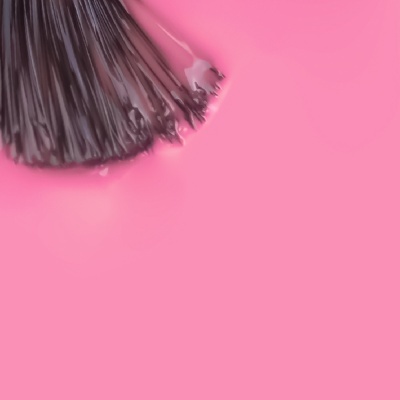 Pincel de maquiagem com cerdas negras e fundo rosa