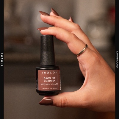 Verniz gel castanho INOCOS na mão com unhas pintadas castanho.