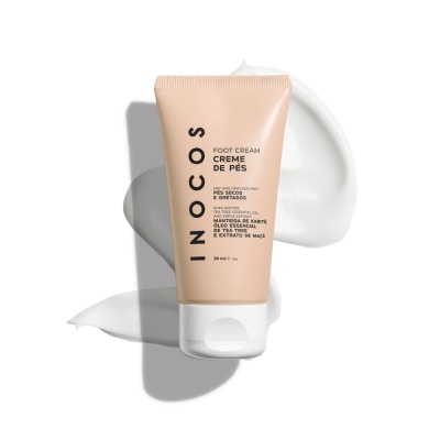 Bisnaga de creme de pés INOCOS bege com tampa branca e texto, sobre fundo branco com creme espalhado