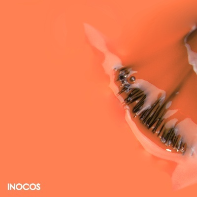 Unha artificial com padrão preto sobre fundo laranja e texto INOCOS