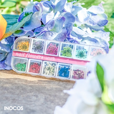 Estojo de enfeites coloridos para unhas com flores lilases ao fundo