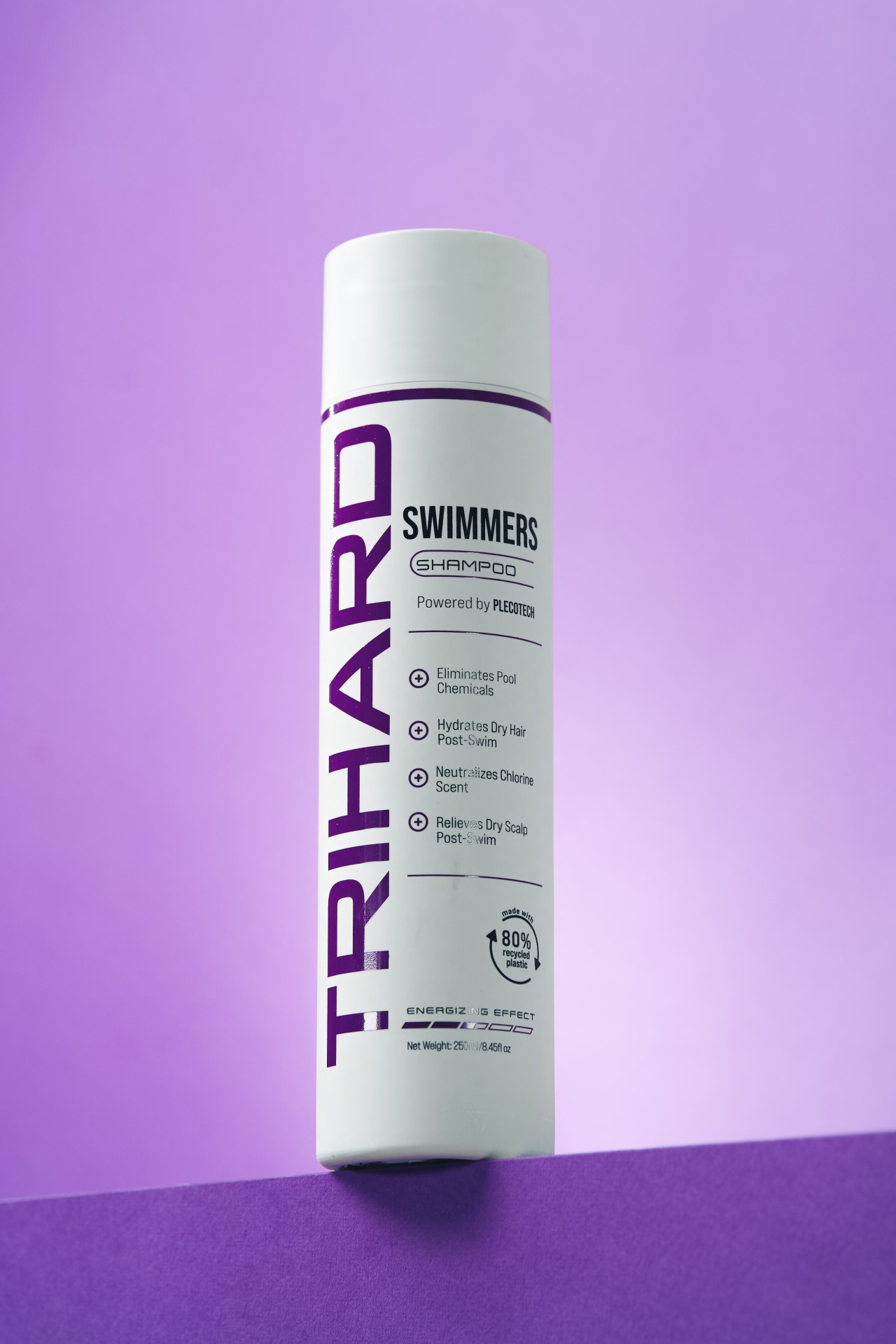 Swimmer's Shampoo Classic | 250ml Frasco branco de champô TRIHARD SWIMMERS com texto roxo e preto sobre fundo roxo e lilás