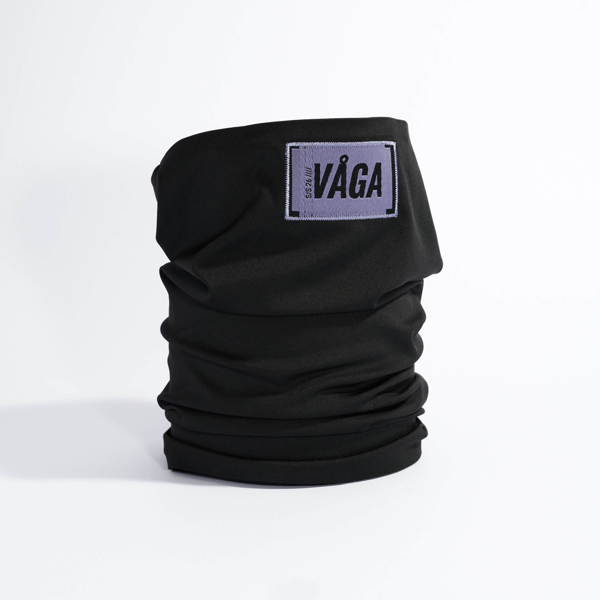 SUPERSOFT MIDWEIGHT NECK GAITER - BLACK Gola tubular preta com etiqueta roxa bordada com o texto VAGA.