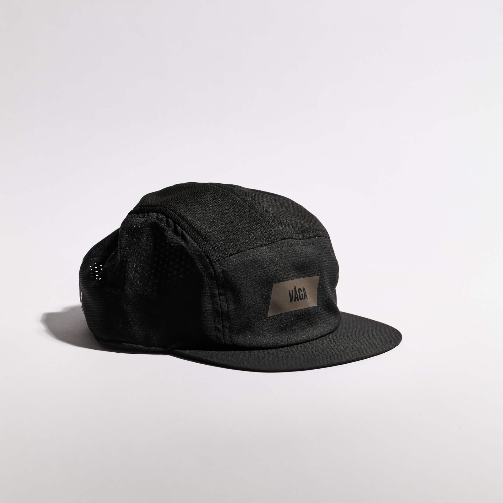 VÅGA FEATHER RACING CAP - BLACK Boné preto com etiqueta VÅGA em fundo branco