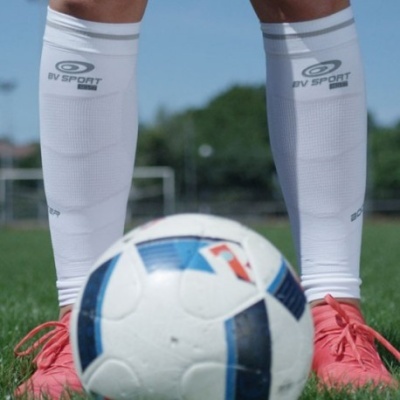 Meias desportivas brancas BV SPORT com bola de futebol e calçado cor de rosa em relvado