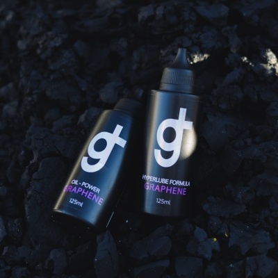 Dois frascos pretos com texto branco e rosa em fundo preto irregular