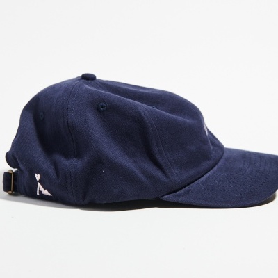 Boné azul escuro em tecido com aba curva e ajuste posterior em metal dourado