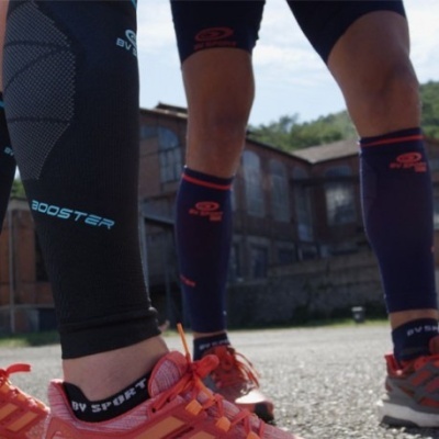 Pernas com meias e calças de compressão desportivas e ténis ao ar livre