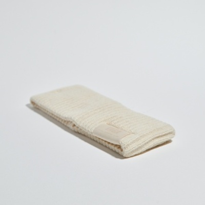 Peça têxtil bege dobrada sobre fundo branco