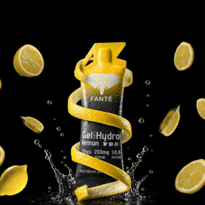 Gel energético FANTÉ Gel Hydro lemon com casca de limão enrollada e fatias de limão ao fundo preto