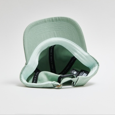 Boné verde claro com pala rígida visto de baixo, sobre fundo branco