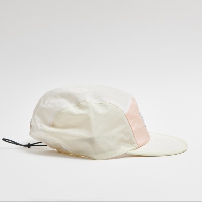 Boné branco com detalhe rosa claro, num fundo branco.