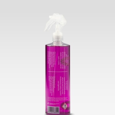 Frasco de spray transparente com líquido roxo e etiqueta roxa, fundo cinzento