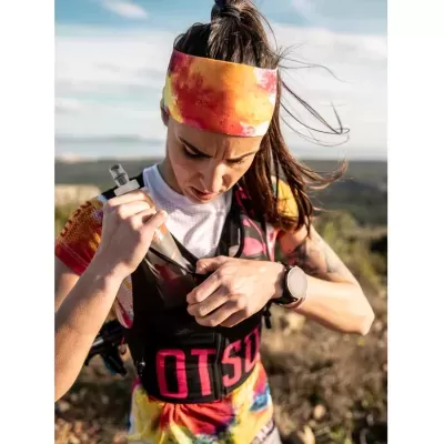 Mulher com roupa desportiva e banda colorida na cabeça ao ar livre