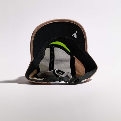 Vista interior da aba de um boné com detalhes em preto, castanho, branco e verde.